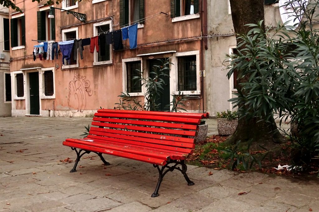 eine rote alte Bank auf einem kleinen Platz mitten in Venedig